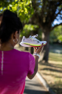 Une femme qui tient dans sa main une paire de chaussure. 
